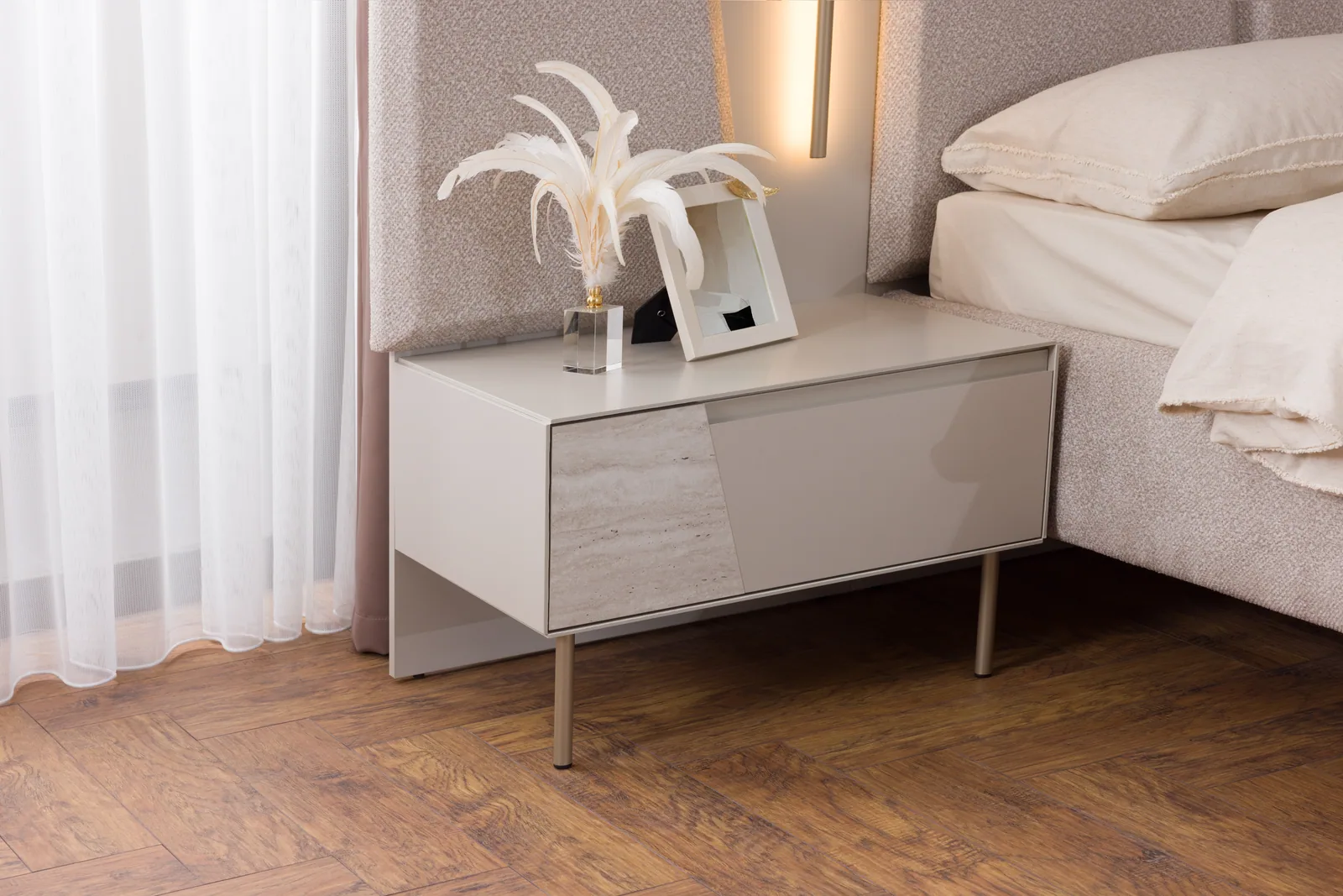 A bedside table stands next to the bed; its top is close to mattress height, at 45-55 cm.